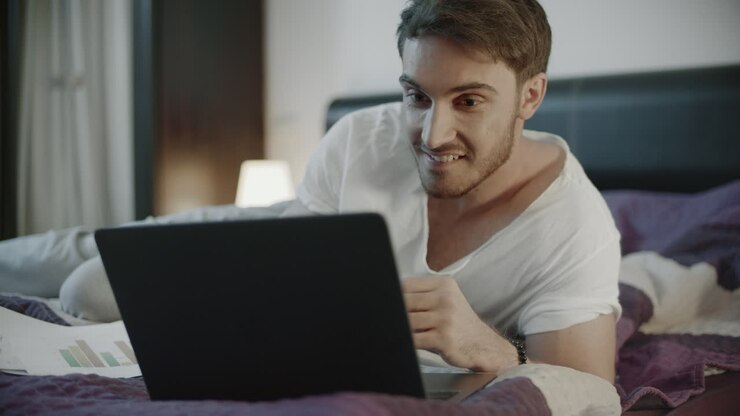 Happy man using laptop computer at home