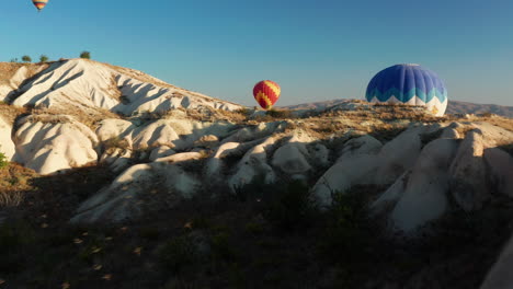 volando a través del paisaje de turquía mientras una bandada de pájaros pasa con un globo de aire caliente en el fondo