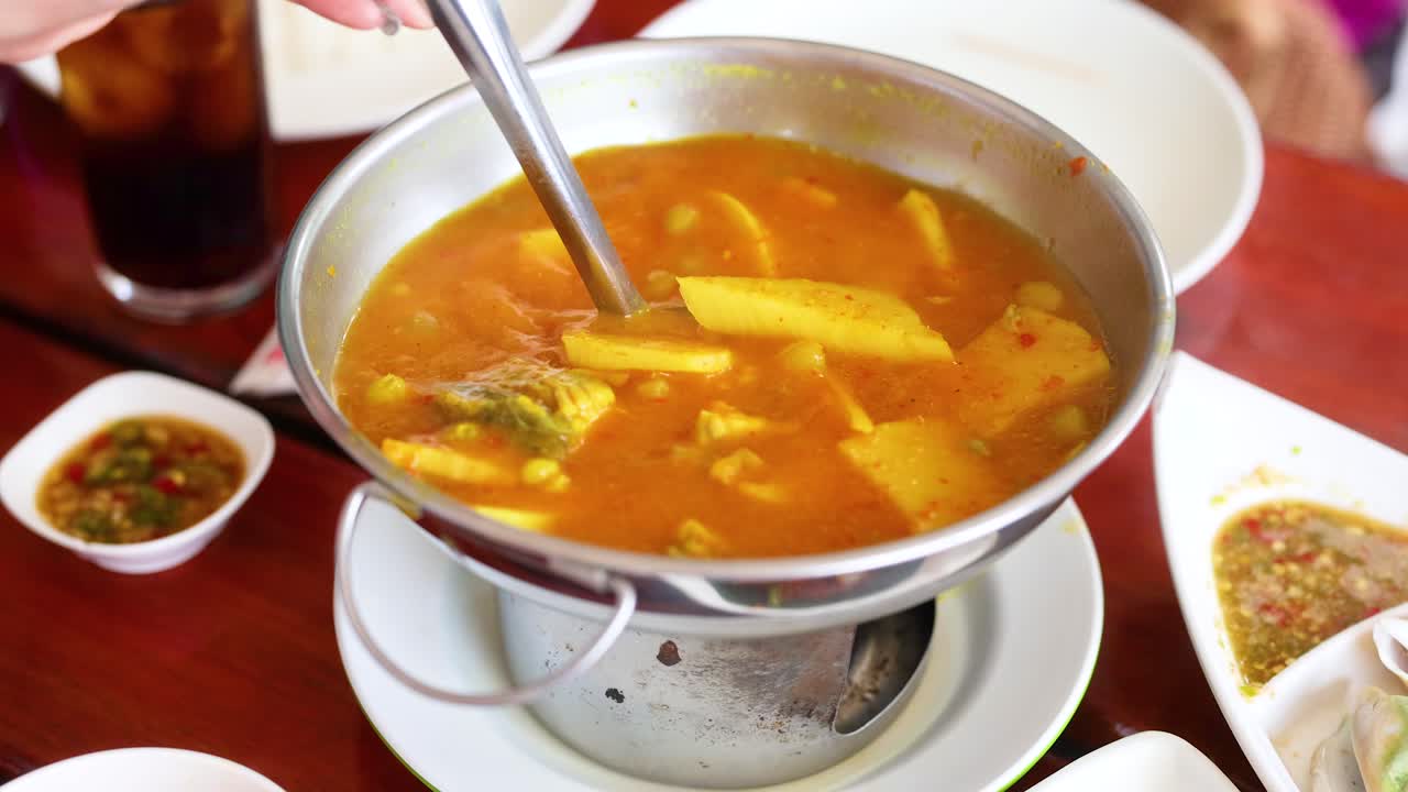 una secuencia que muestra el servicio de sopa kaeng som en un restaurante tailandés, destacando los colores vibrantes y la presentación tradicional