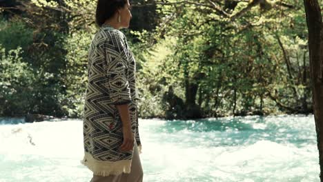 mujer disfrutando de la naturaleza junto a un río en un bosque