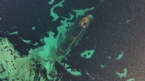 aerial view of a sunken shipwreck in clear turquoise water