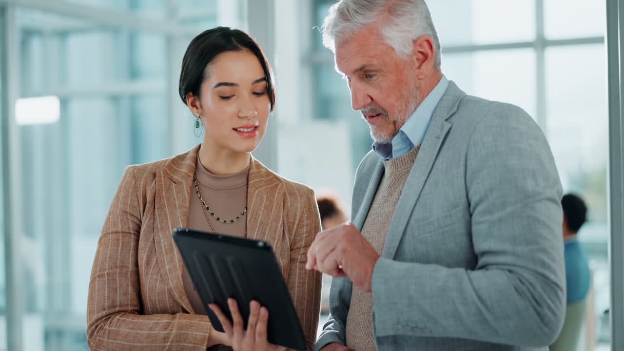 Geschäftskollegen diskutieren über Arbeit auf einem Tablet