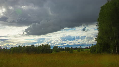 time lapse of rainy clouds moving fast over a grassland