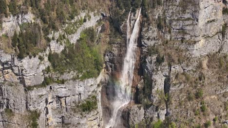 Seerenbach-Falls-cascading-down-a-rugged-cliff-face-surrounded-by-greenery-in-Amden,-Betlis,-near-Walensee,-Switzerland