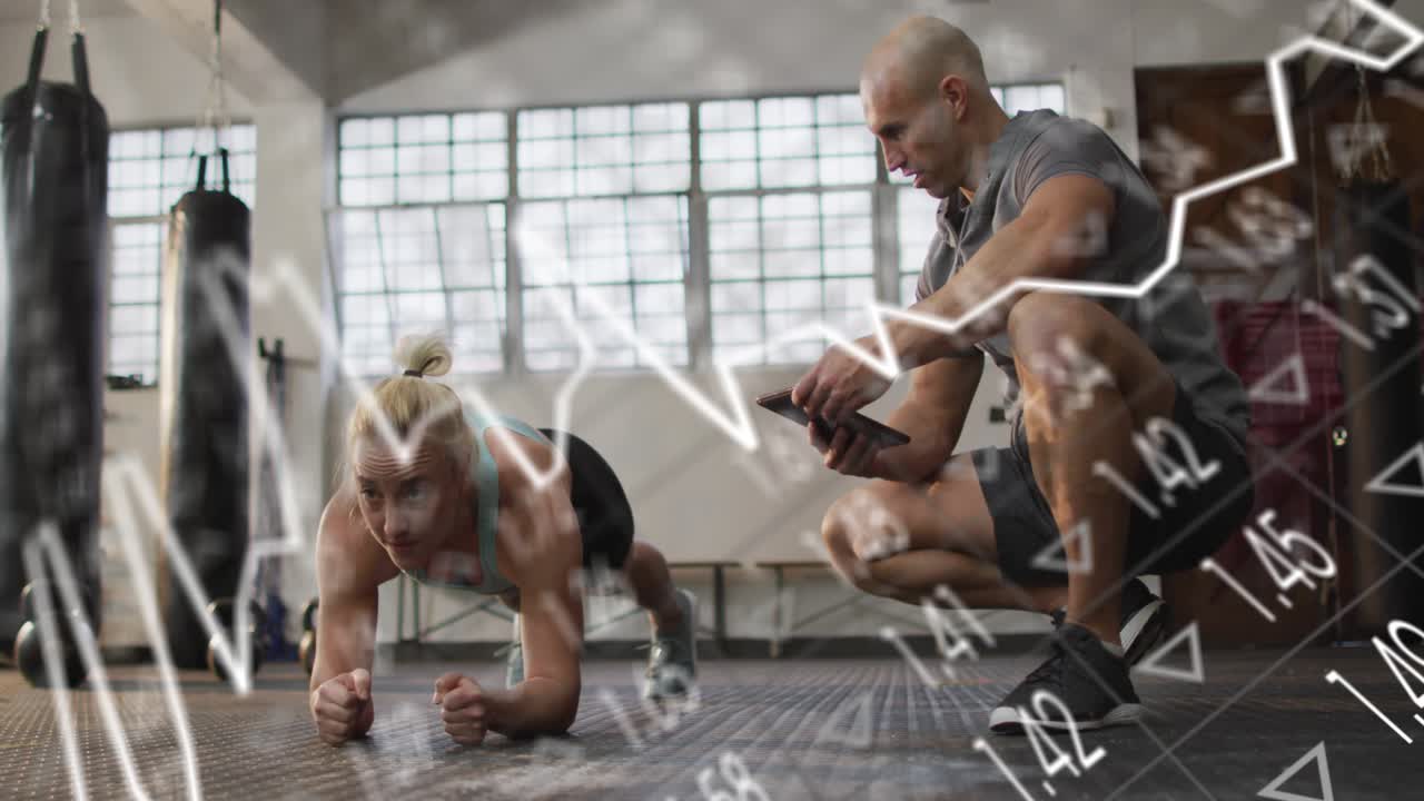 Woman doing forearm plank in gym; coach tapping phone causing line and bar charts tracking fitness