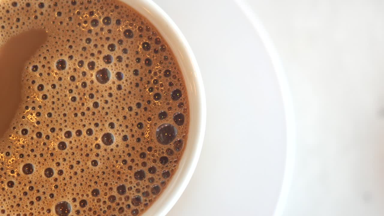 vista de arriba de café caliente con burbujas sobre fondo blanco ,