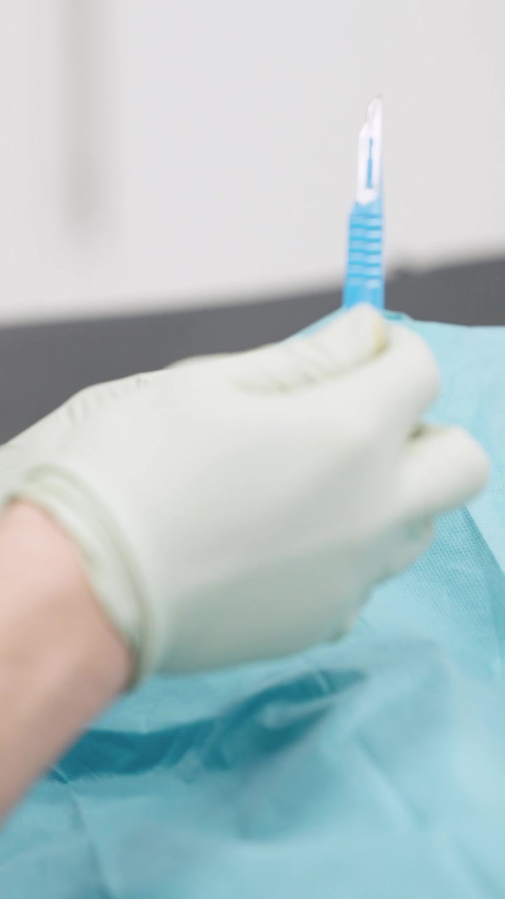Chirurgo che esegue un piccolo intervento dermatologico con bisturi
