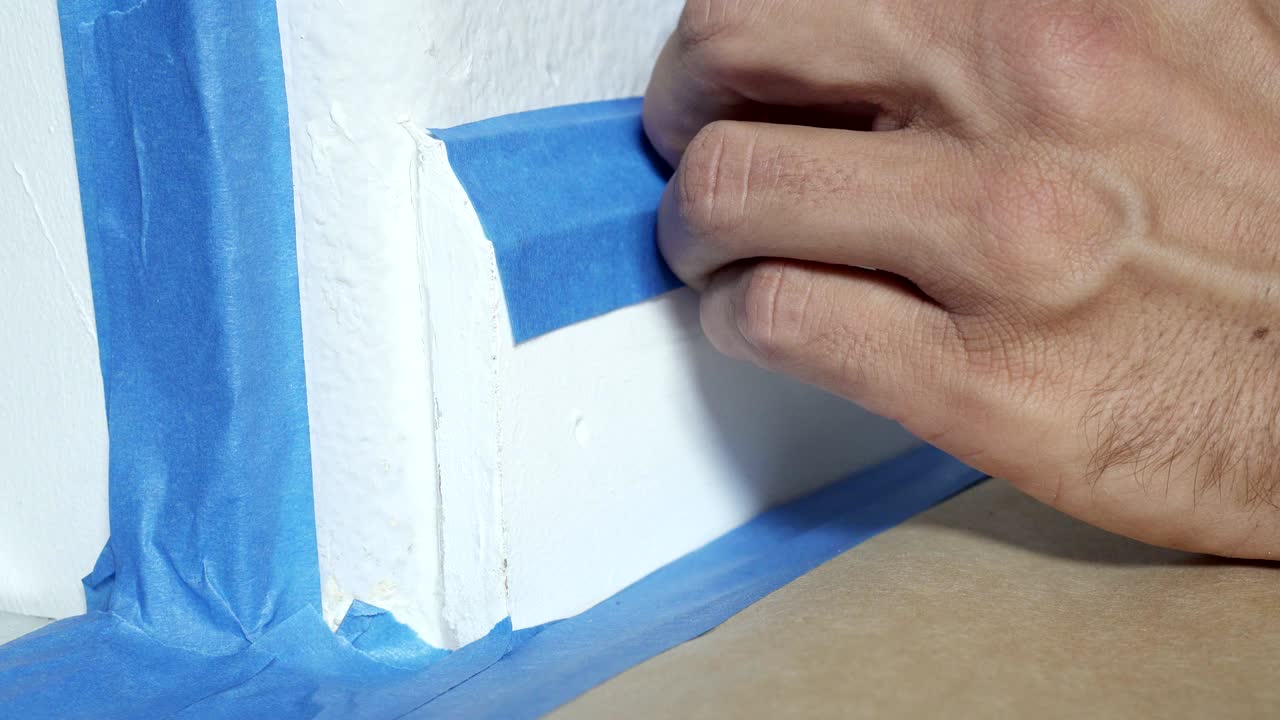 4k, Painter Using Masking Blue Tape to Secure Baseboard, Moulding. Preparation For Room Painting.