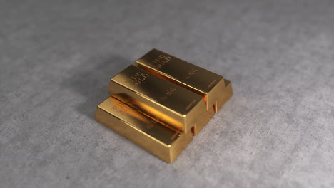 gyratory view of five bullions. a stack of gold bars on a white concrete background