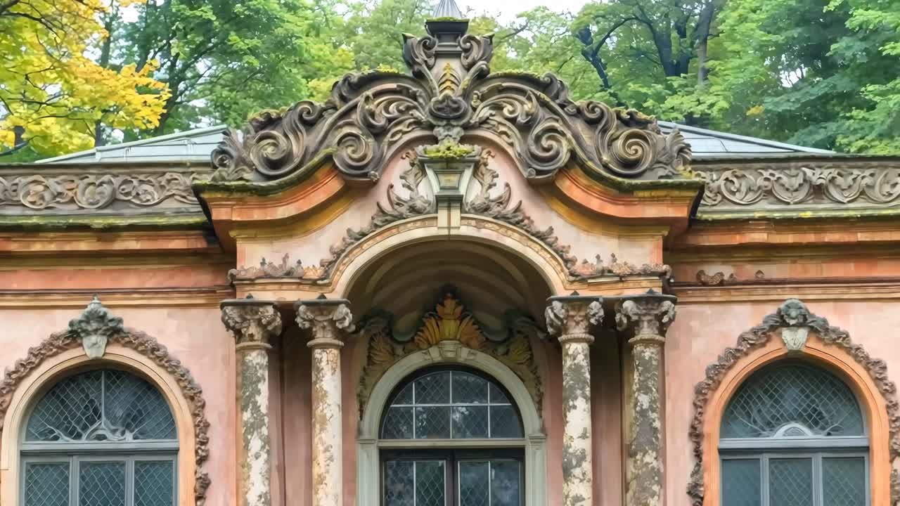 핑크색 건물 앞면에 장식된 조각이 있습니다.