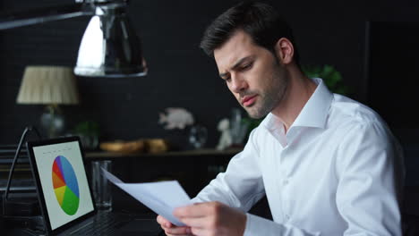 hombre de negocios mirando gráficos en la pantalla de un portátil. gerente trabajando con papeles