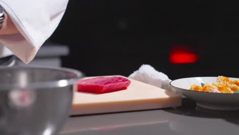 a static shot captures a sushi chef placing fresh cucumber slices on sushi rolls in a bowl, showcasing the final touch of preparation. ideal for culinary, sushi, and food presentation content.