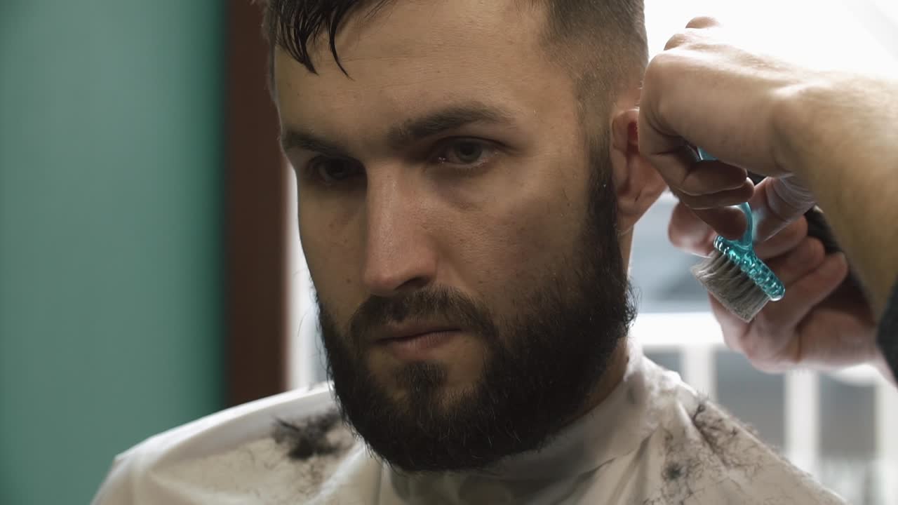 Man getting a haircut and beard trim at a barbershop