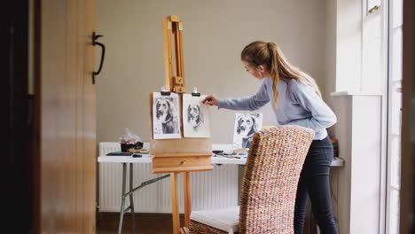 Blick-Durch-Die-Tür-Auf-Eine-Teenager-Künstlerin-An-Der-Staffelei,-Die-Mit-Kohle-Ein-Bild-Eines-Hundes-Zeichnet