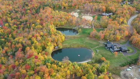 aerial view of colorful forest, ranch ponds and mansion in american countryside