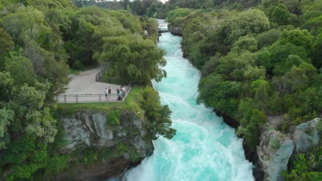 Aerial-drone-flying-backwards-above-raging-Huka-Falls,-New-Zealand