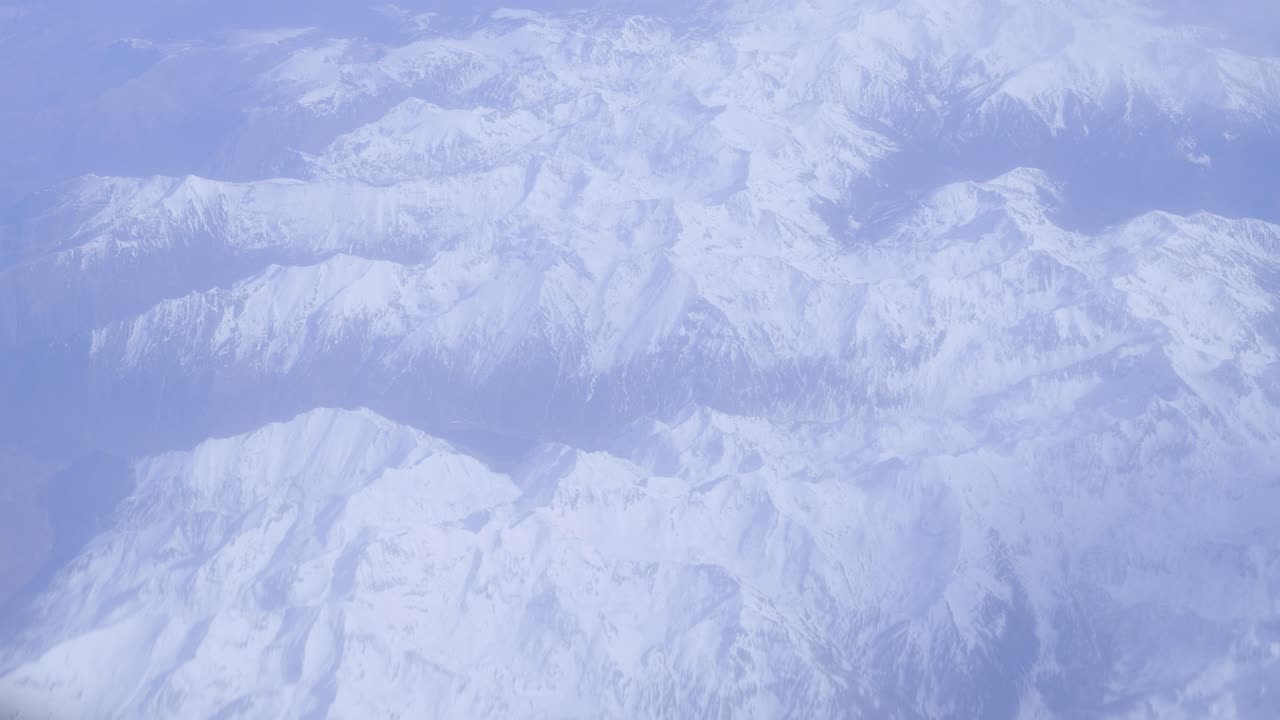 Snow-covered mountain peaks from an aerial view, peaceful and majestic landscape