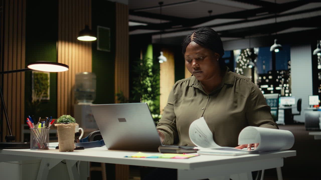 Black employee proofreading and fact checking financial numbers