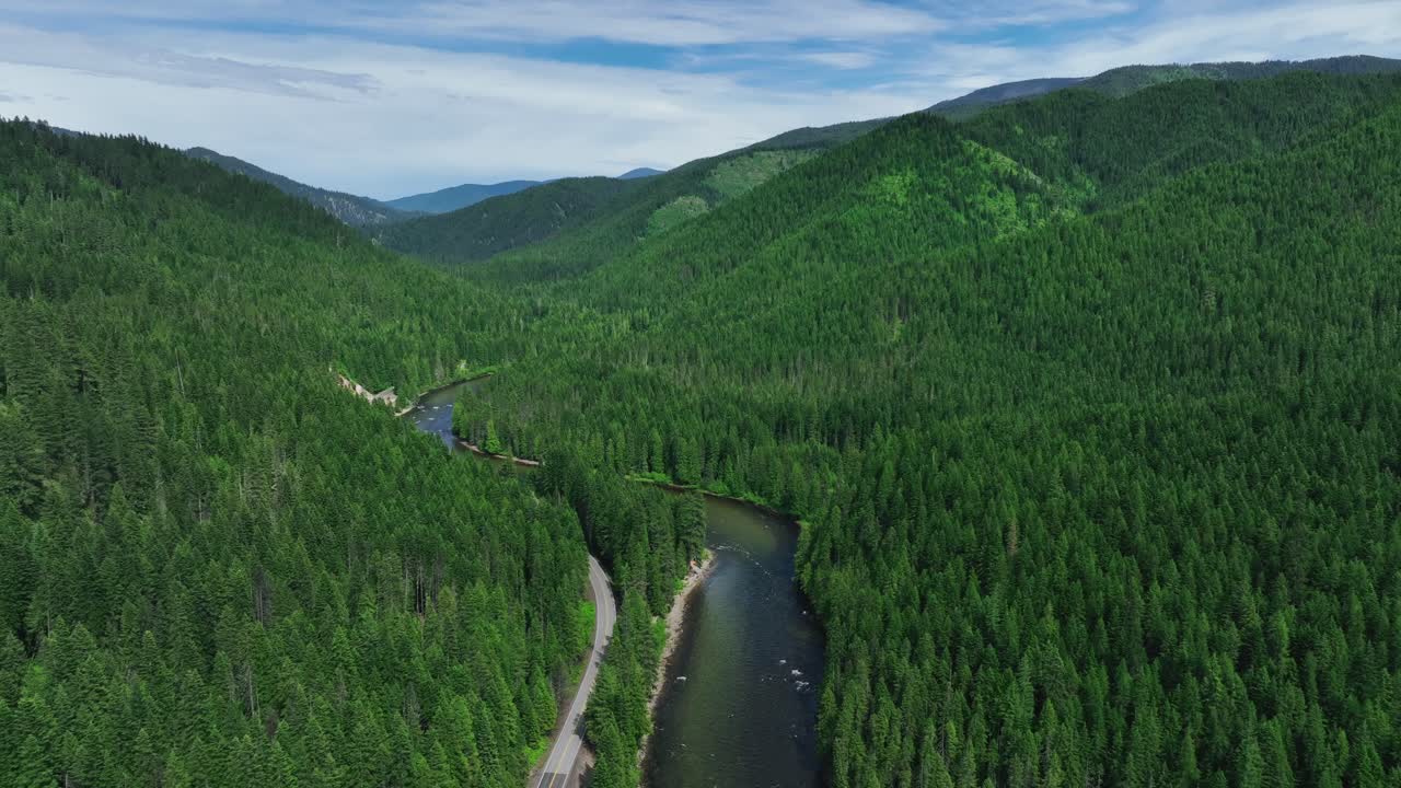 vista aérea del arroyo y la carretera de montaña a través de un denso bosque de pinos en lolo, missoula, montana