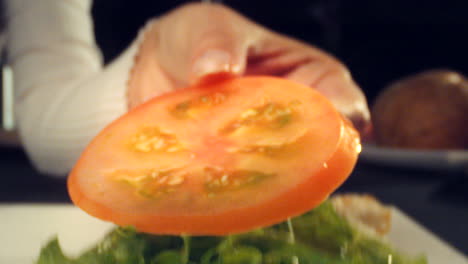 detail shot, preparation of ham, cheese, lettuce and tomato sandwich