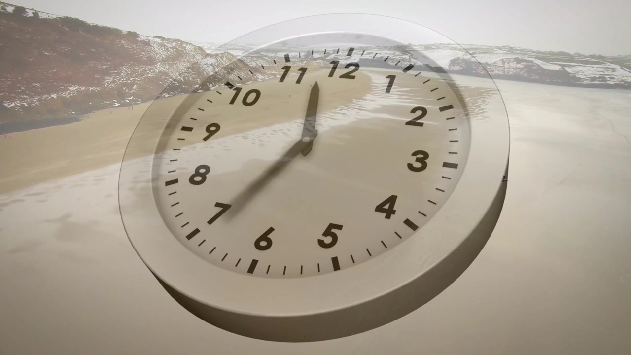 Kamera kaydırırken kıyı üzerinde süzülen şeffaf bir saat, akrep ve yelkovanı saat yönünde hareket ederek zamanı gösteriyor.