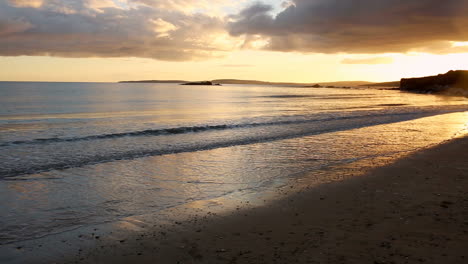 Woman-running-along-the-water-at-sunset