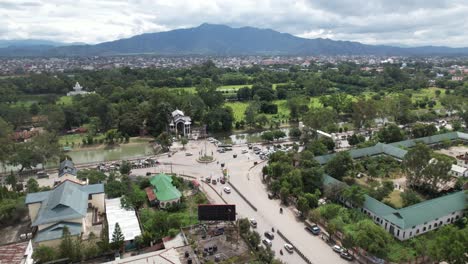 Aerial-Drone-Shot-Of-Buildings,-Highway-Junction,-Mountains,-Trees-And,-Cars-In-India