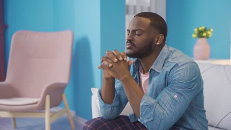 Stressed-african-young-man-sitting-at-home.-Unhappy-expression.