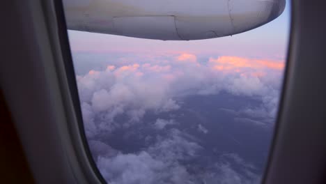 view of beautiful sunset above the clouds, shot from a plane window