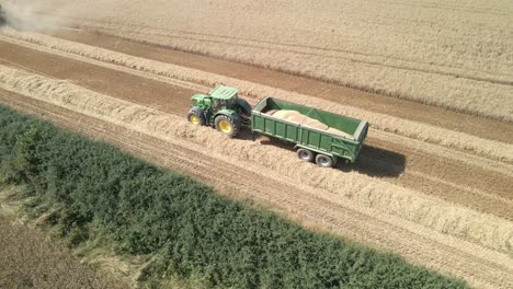 aerial footage of a combine harvester and tractor harvesting a wheat crop