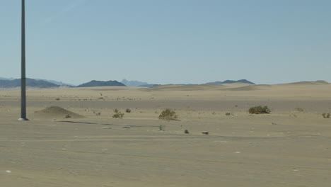 el punto de vista de una persona dentro de un auto conduciendo en el desierto de arabia saudita en el medio oriente