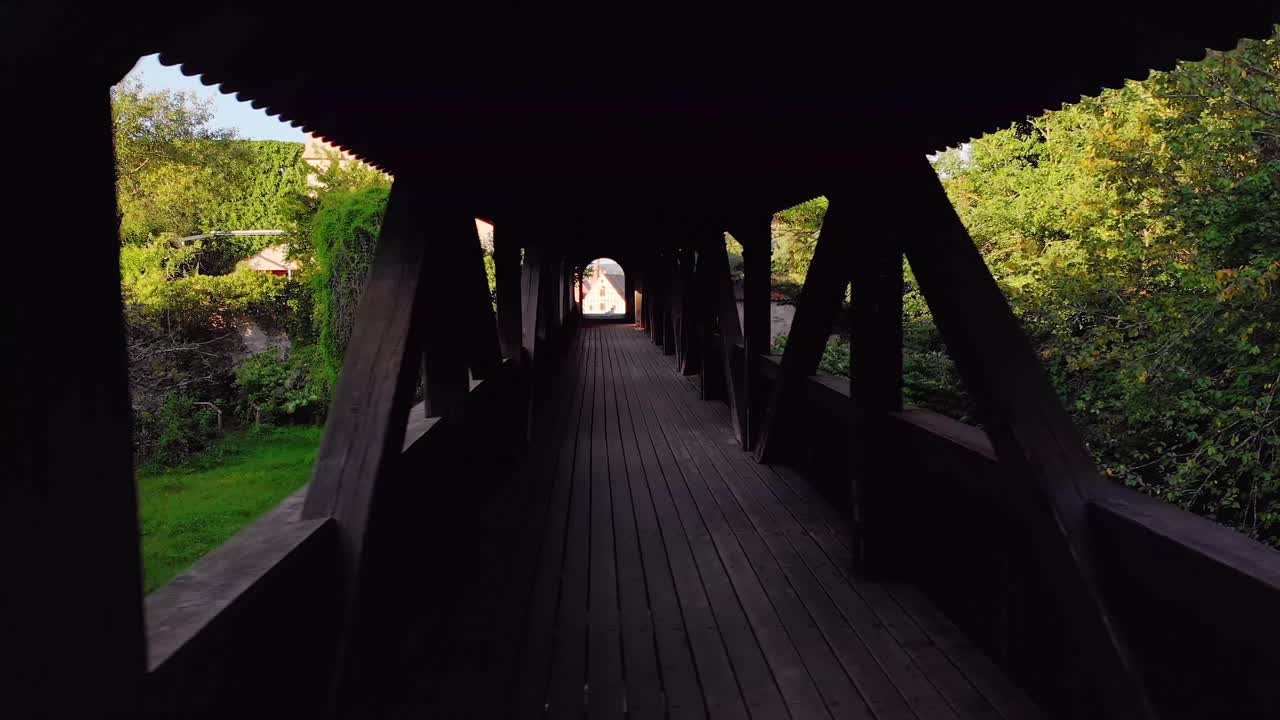 무인 항공기가 나무로 덮힌 다리를 가로질러 날아갑니다.