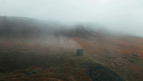 standedge tunnel ventilation chimney high on the pennine hills smoking as a railway train pass through the tunnel between marsden yorkshire and lancashire