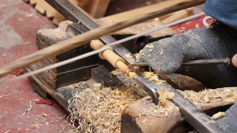 real time close up of a person working and sanding wood manually with his hands and feet