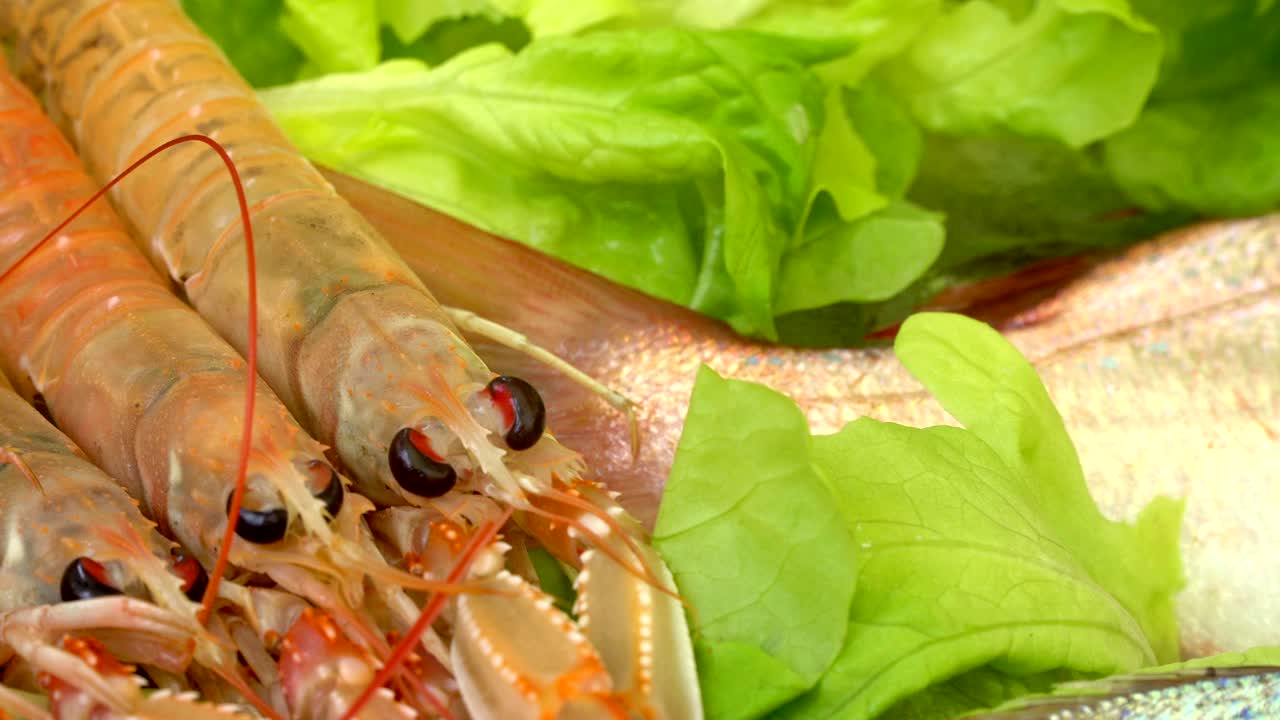 시장에서 얼음 위에 줄지어 있는 해산물, 상점 - 바다 물고기, 새우, 오징어, 크레이피시, 채소로 조리된 해산물.