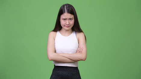 young angry asian businesswoman with arms crossed