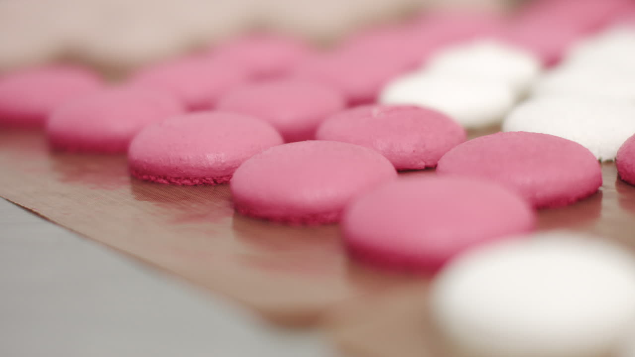 Pink and White Macarons on a Baking Sheet