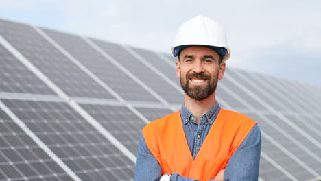 portrait of young male engineer with helmet near solar panels