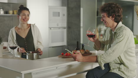 couple cooking and relaxing with wine in a modern kitchen