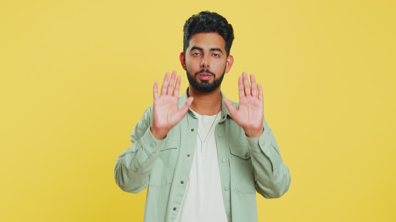 Strict Indian man warning hands gesture, saying no, be careful, advice to avoid danger, caution