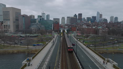 Forwards-tracking-of-train-unit-arriving-into-station.-Subway-tracks-surrounded-by-road.-Cityscape-with-downtown-buildings-in-background.-Boston,-USA