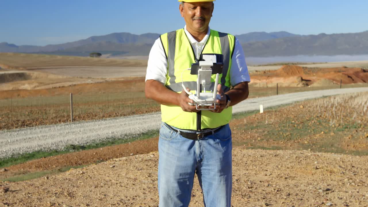 ingeniero masculino que opera un avión no tripulado en el parque eólico 4k
