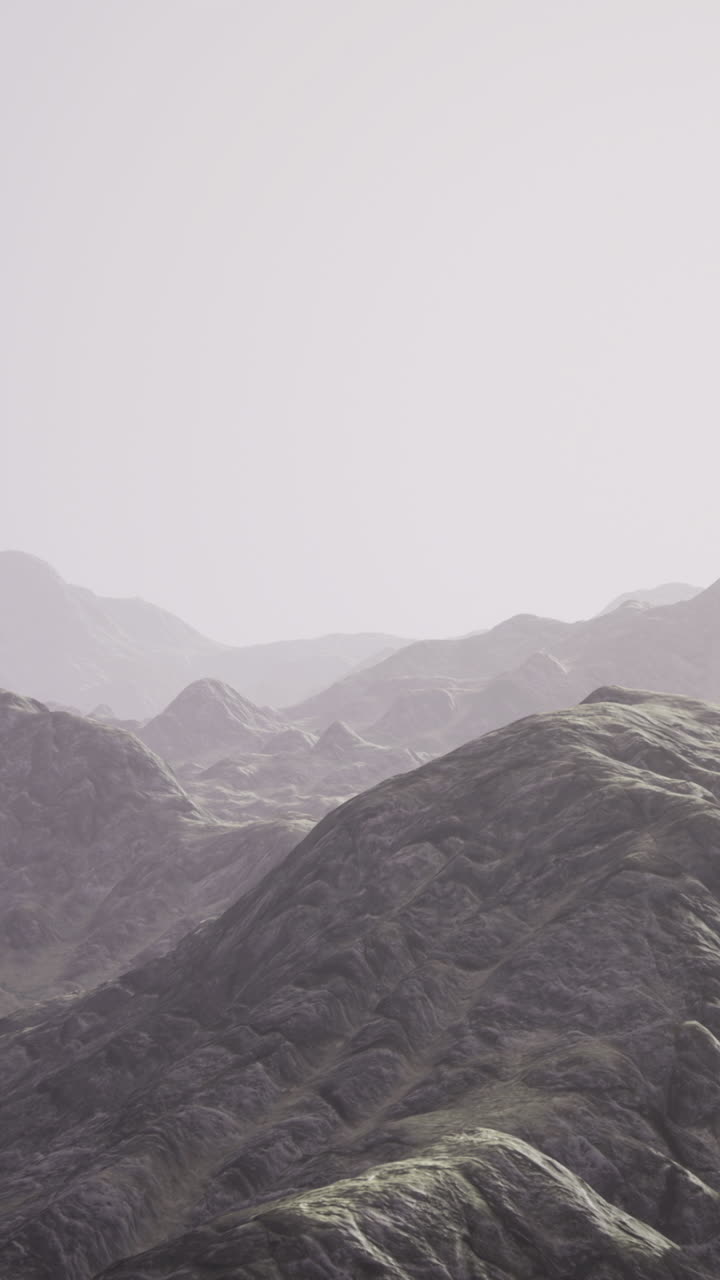 Majestic mountain range under a soft hazy sky at dawn hour