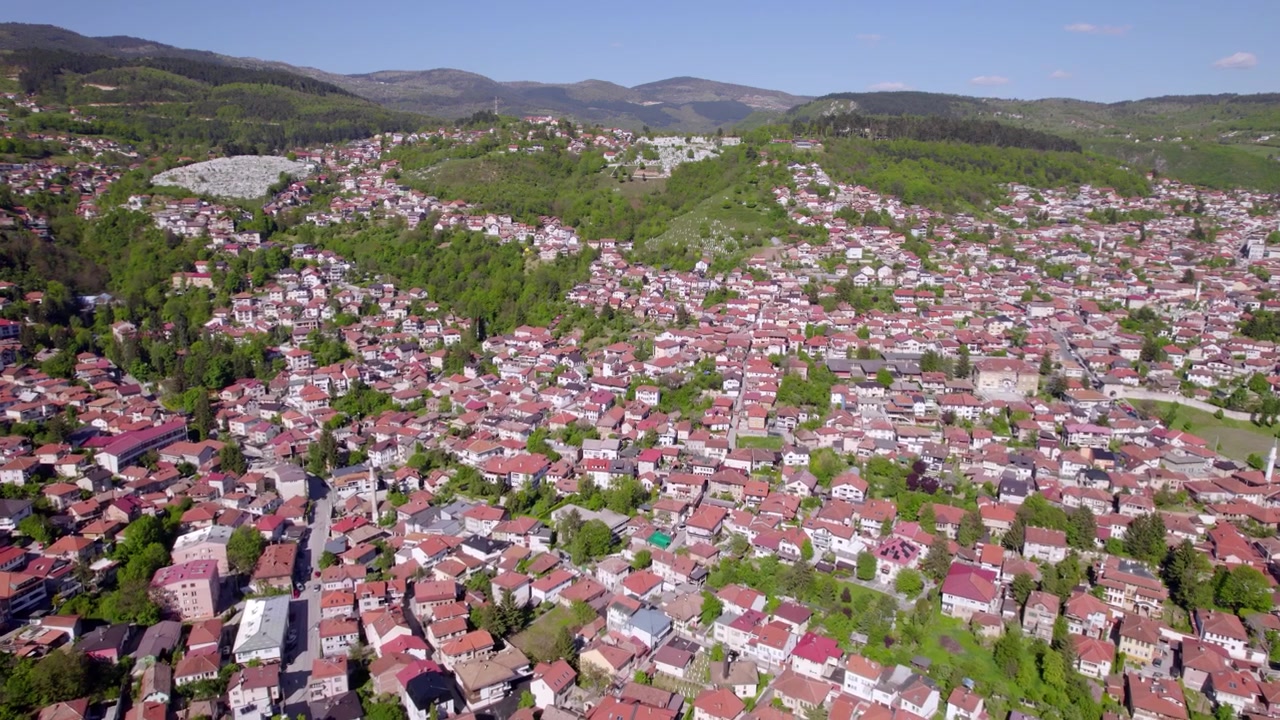 Saraybosna'nın ormanlar ve dağ sıralarıyla çevrili yamaç mahallelerinin havadan panoraması, fon oluşturuyor, Bosna-Hersek