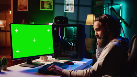 portátil de pantalla verde al lado del hombre divirtiéndose usando el teclado de juego para volar una nave espacial en el videojuego sf