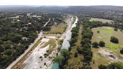 rising above large expanse of river with open recreational areas, homes, fields and trees in foreground