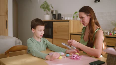 mother and son decorating easter eggs