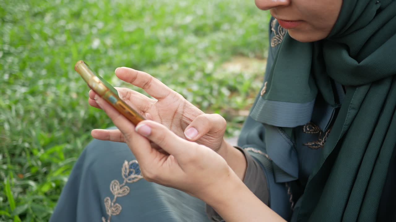 Donna che utilizza smartphone in un parco