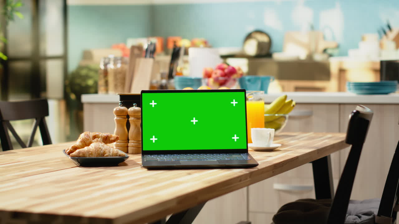 Mockup chroma key sullo schermo di un laptop in interni rustici di cucina con tavolo in legno