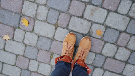 pies en botas de otoño en la acera la cámara gira